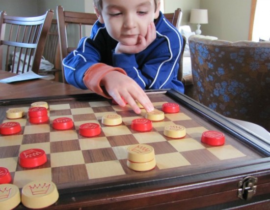 Five year old playing checkers